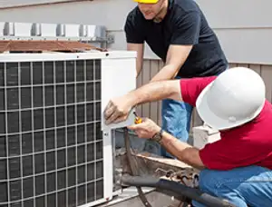 HVAC technicians repairing an outdoor AC unit on a rooftop in Spokane, WA