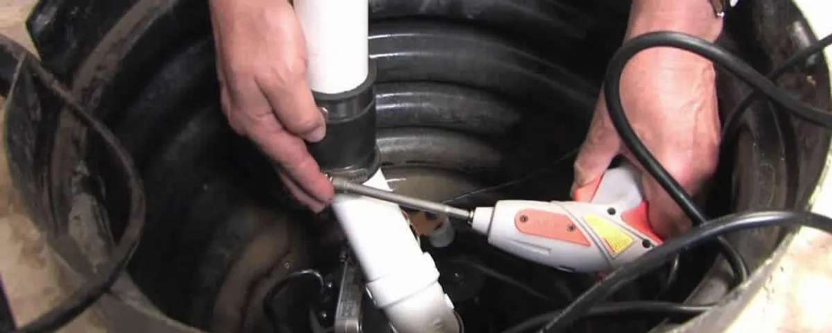 Sump pump installation technician connecting PVC discharge piping in Spokane, WA